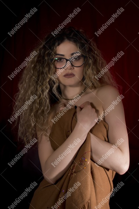 Woman with curly hair wrapped in a scarf posing sexy for camera
