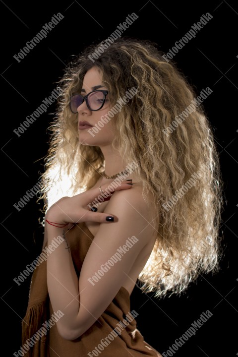 Woman with curly hair wrapped in a scarf posing sexy for camera