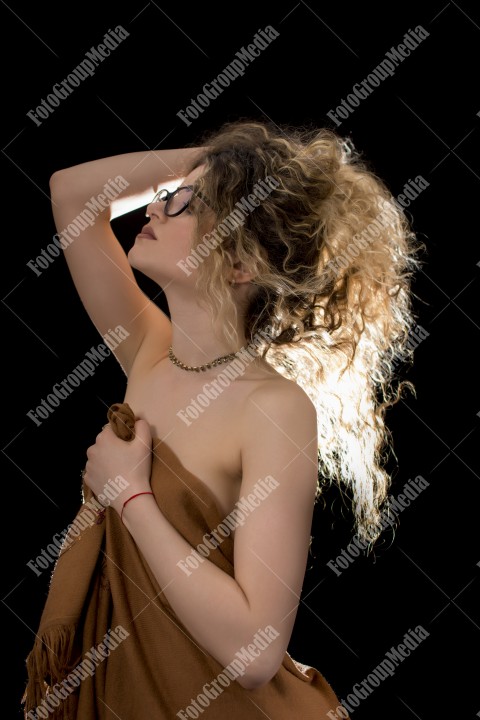 Woman with curly hair wrapped in a scarf posing sexy for camera