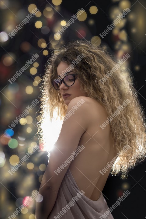 Woman with curly hair wrapped in a scarf posing sexy for camera