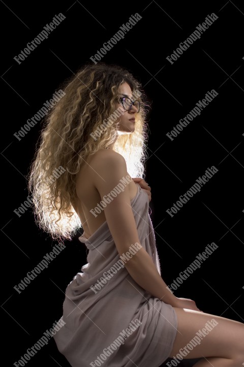 Woman with curly hair wrapped in a scarf posing sexy for camera