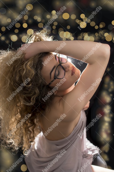 Woman with curly hair wrapped in a scarf posing sexy for camera