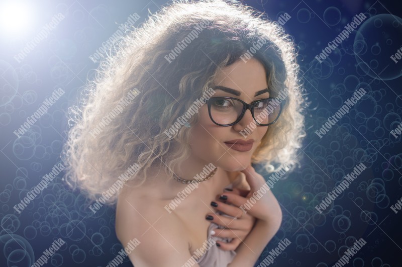 Woman with curly hair wrapped in a scarf posing sexy for camera