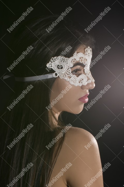 Hiding behind lace mask, studio shoot