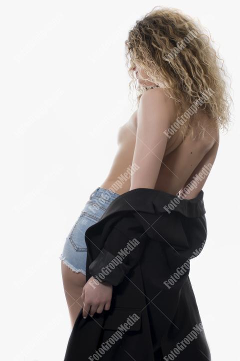 Sexy curly haired woman with perfect body dressed in jeans on white isolated