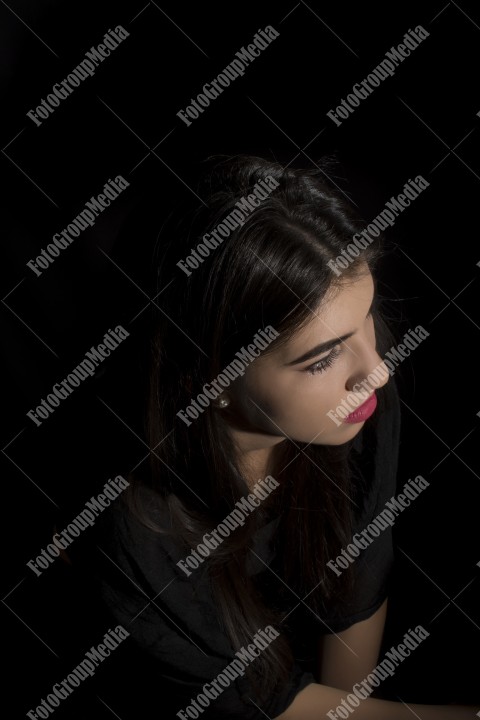 Headshot of beautiful young woman on black background