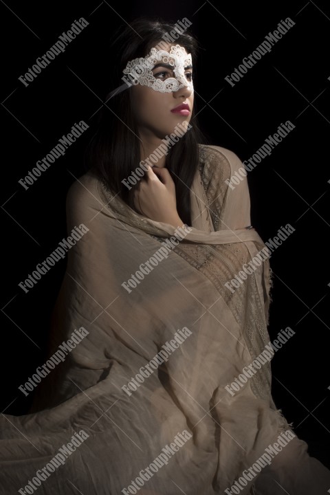 Young woman with lace mask and covered in big shawl