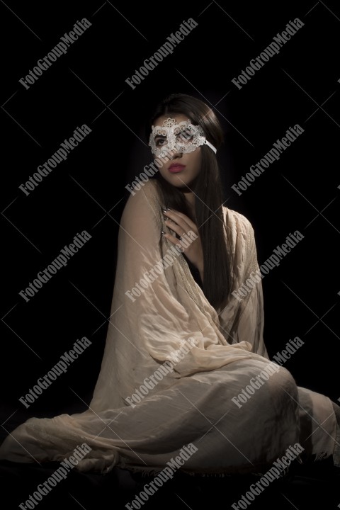 Young woman with lace mask and covered in big shawl