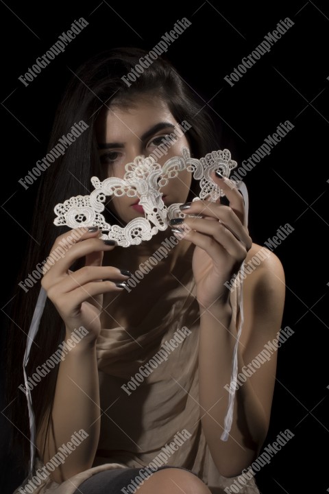 Young woman with lace mask and covered in big shawl