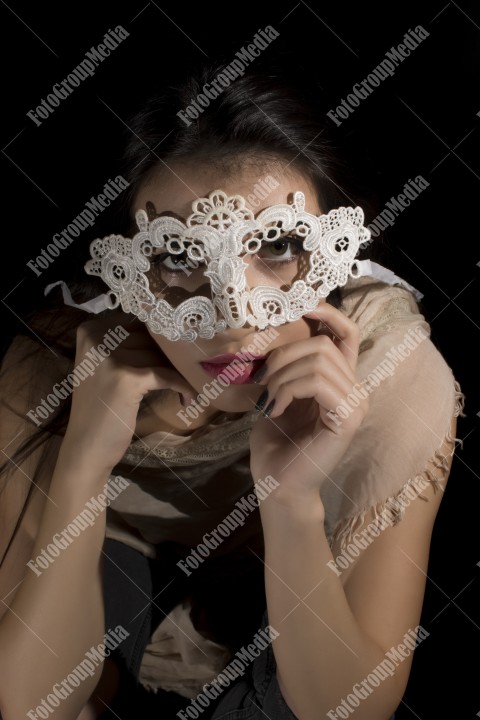 Young woman with lace mask and covered in big shawl
