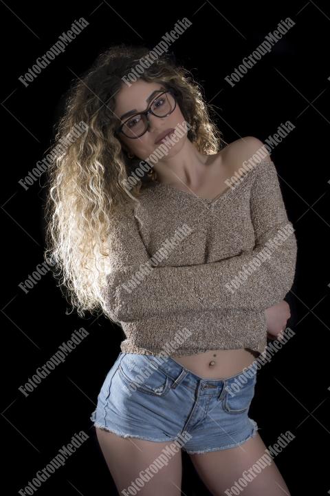 A confident young woman poses casually, studio shot
