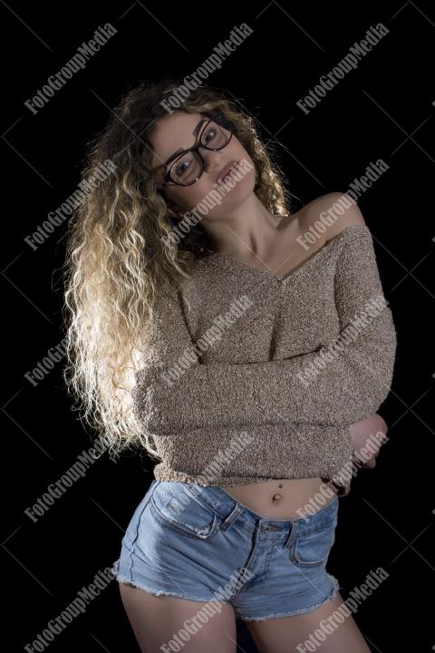 A confident young woman poses casually, studio shot