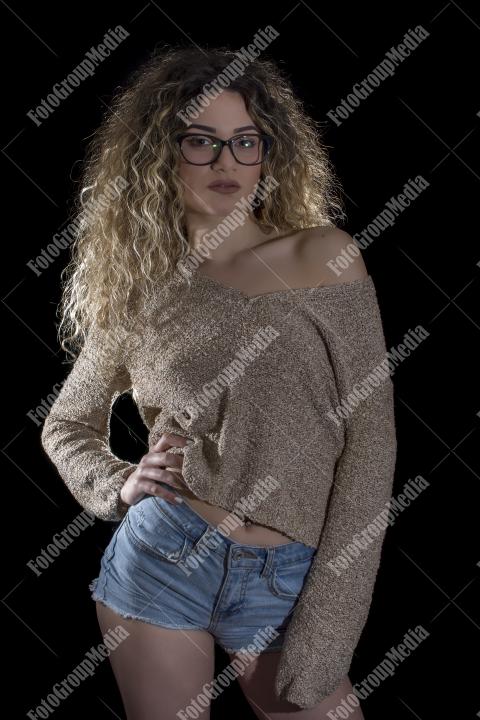 A confident young woman poses casually, studio shot