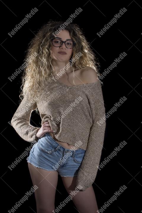 A confident young woman poses casually, studio shot