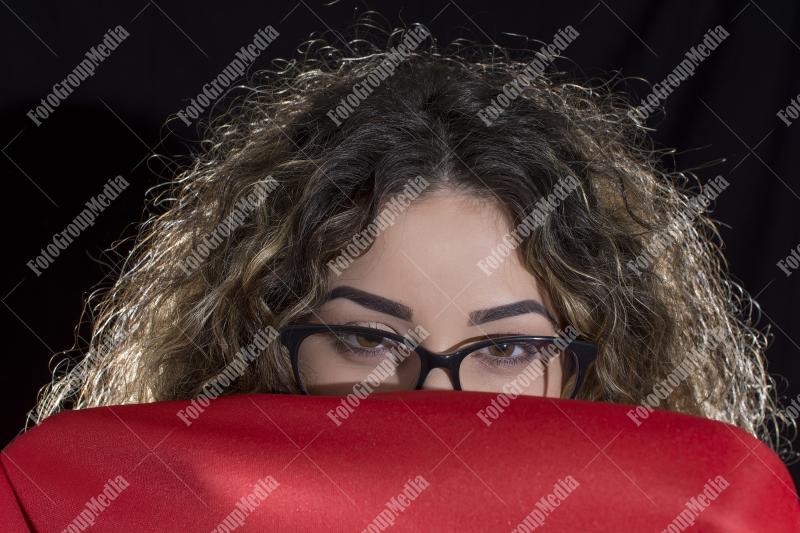 Mysterious figure draped in a bold red cape, studio shot