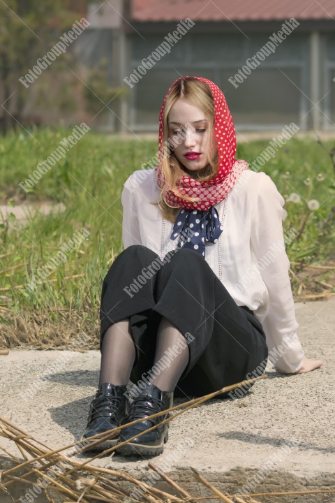 Young woman sitting on ground looking down