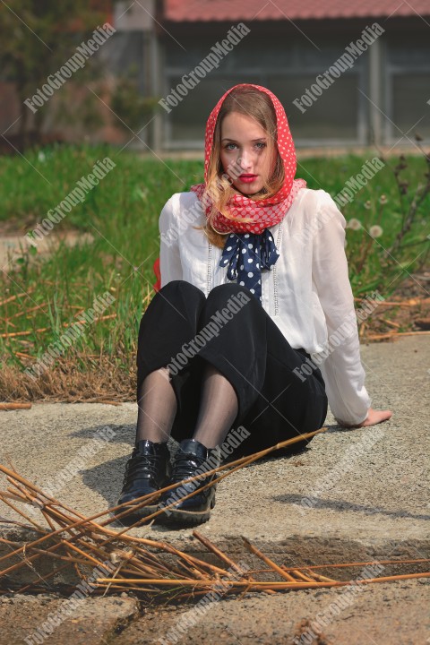 Young woman sitting on ground looking at camera