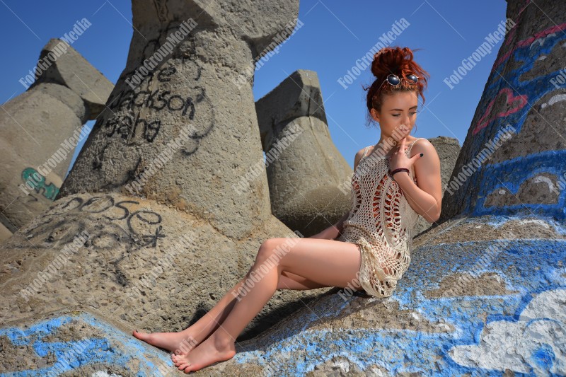 Beautiful redhead young woman in a stylish summer knit clothes posing outdoor