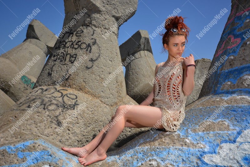 Beautiful redhead young woman in a stylish summer knit clothes posing outdoor