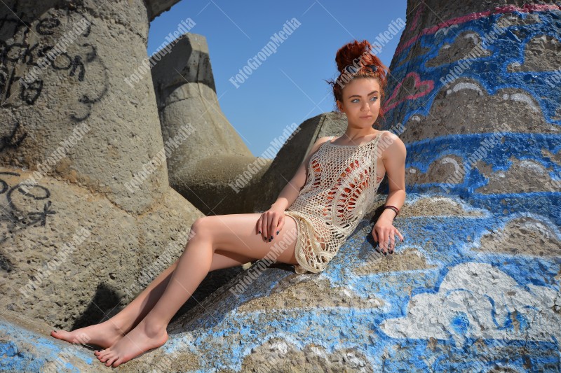 Beautiful redhead young woman in a stylish summer knit clothes posing outdoor