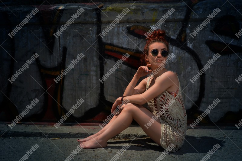 Beautiful redhead young woman in a stylish summer knit clothes posing outdoor