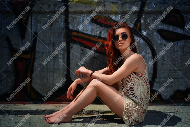 Beautiful redhead young woman in a stylish summer knit clothes posing outdoor