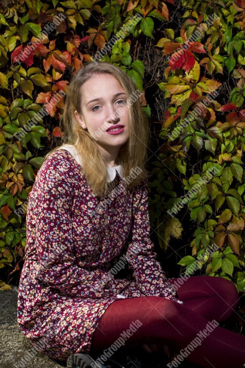 Blond girl posing in autumn day on colorful leafs background