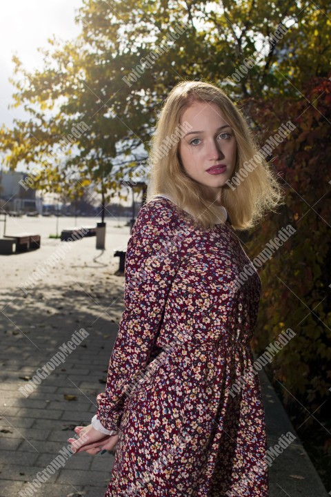 Girl with red dress and posing on street