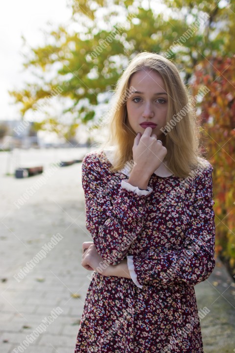 Girl with red dress posing on street