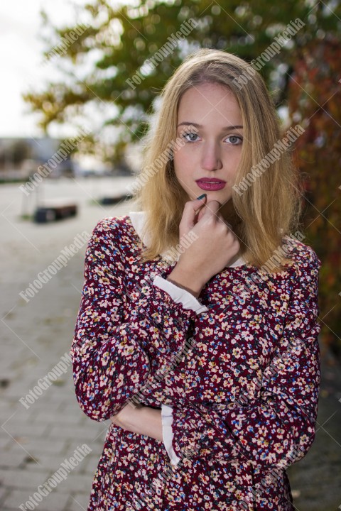 Girl with red dress posing on street