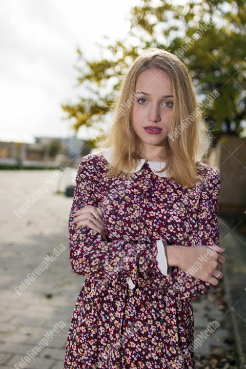 Girl with red dress posing on street