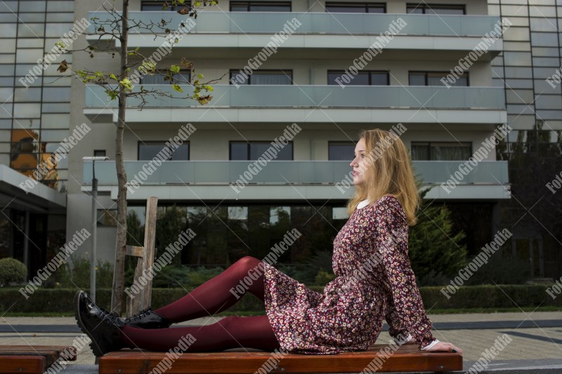 Girl with red dress posing on bench