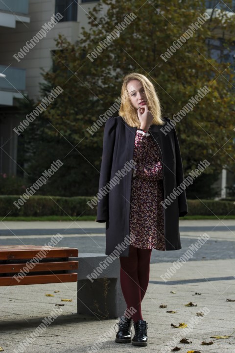 Girl with red dress and black coat on street