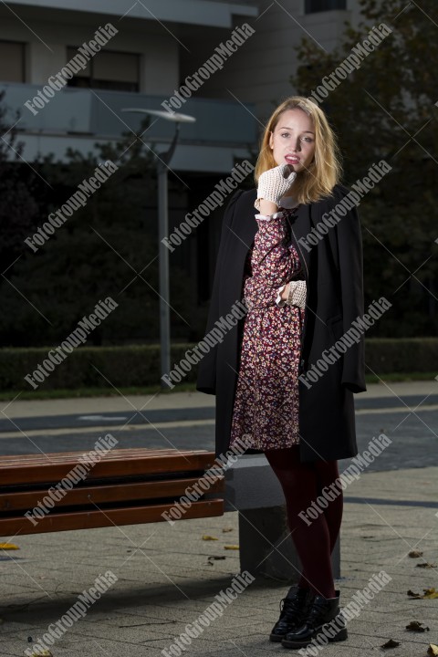 Girl with red dress and black coat on street