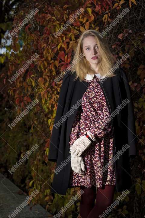 Blond girl posing in autumn day on colorful leafs background