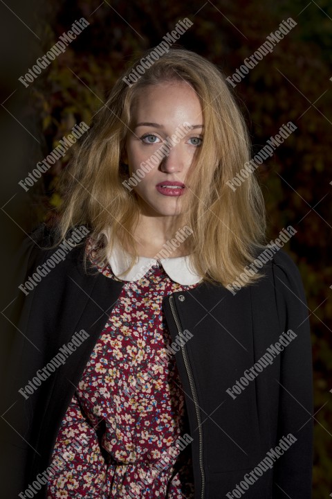 Blond girl posing in autumn day on colorful leafs background