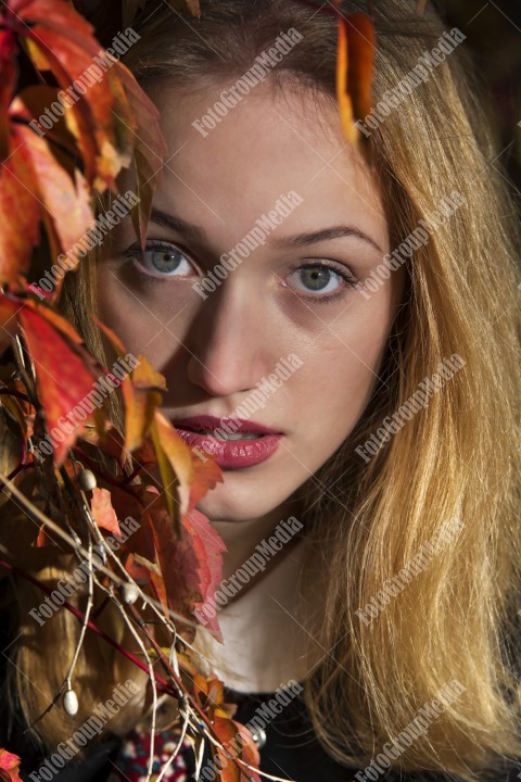 Art portrait of a young blonde woman in autumn background