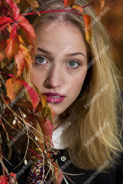 Art portrait of a young blonde woman in autumn background