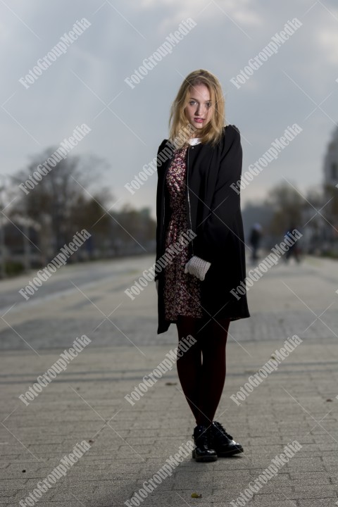 Girl with red dress and black coat on street