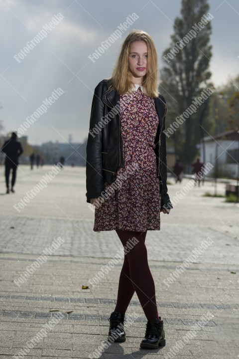 Girl with red dress and leather jacket on street