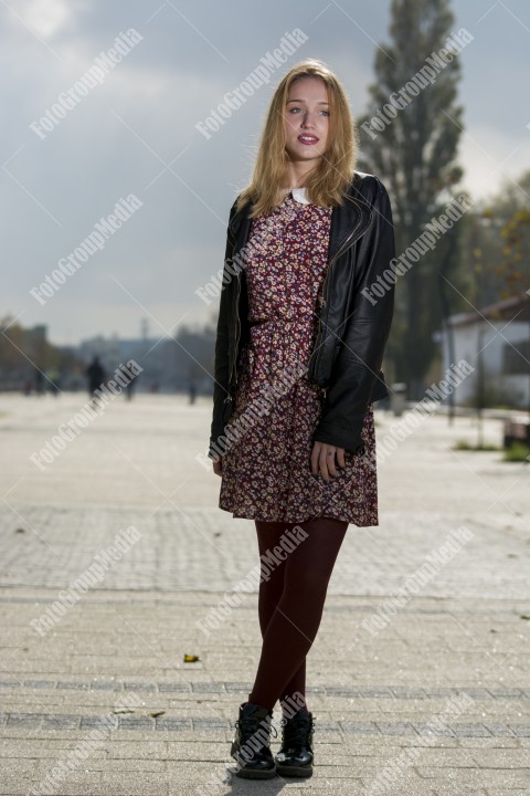 Girl with red dress and leather jacket on street