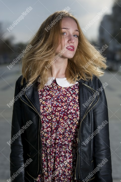 Girl with red dress and leather jacket on street