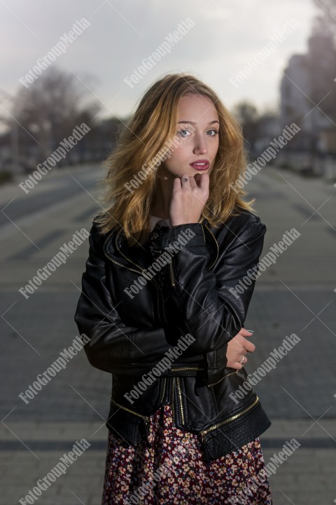 Girl with red dress and leather jacket on street