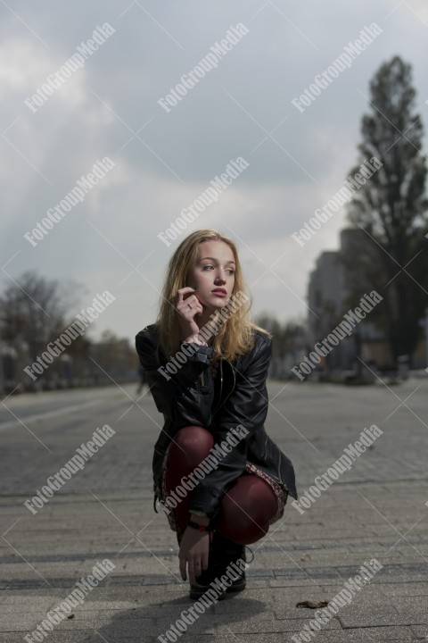 Girl with red dress and leather jacket on street