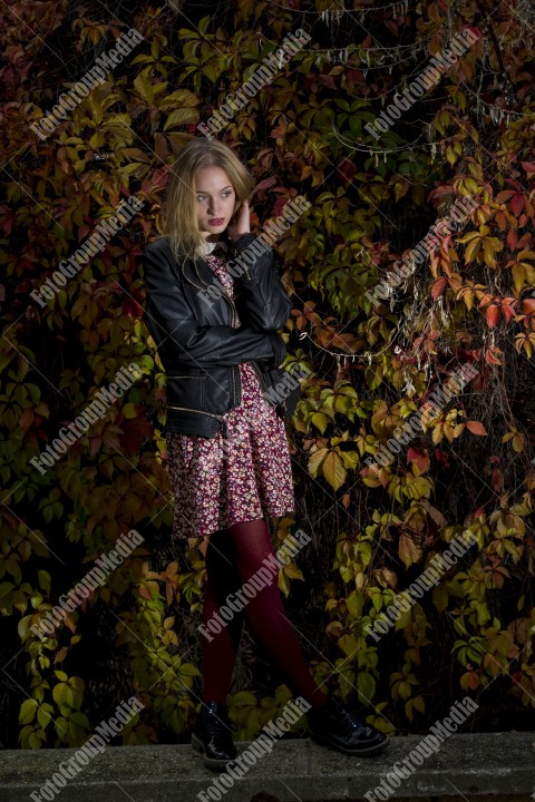 Blond girl posing in autumn day on colorful leafs background