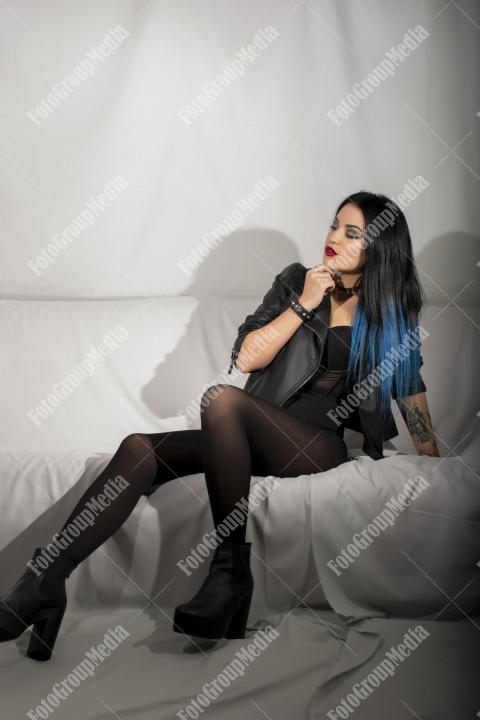 Woman posing in lingerie and leather jacket on white background