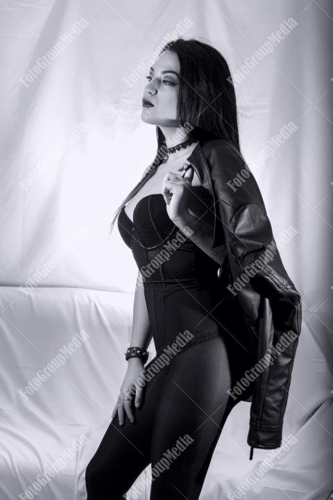 Woman posing in lingerie and leather jacket on white background