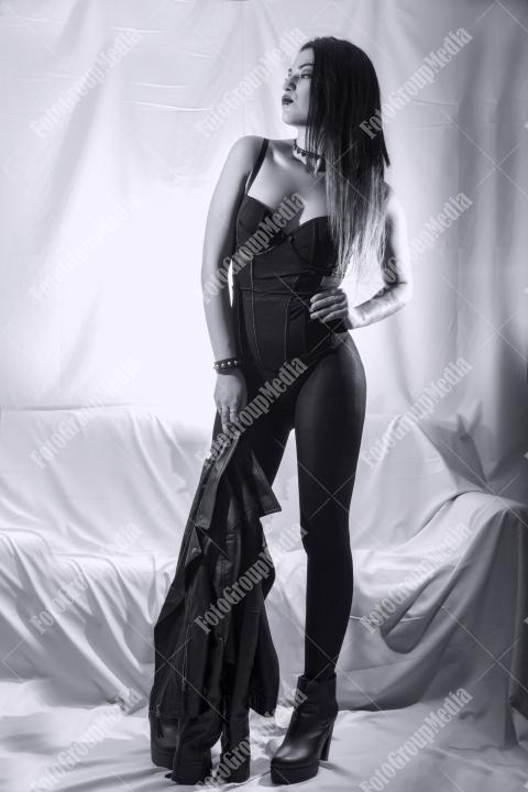 Woman posing in lingerie and leather jacket on white background