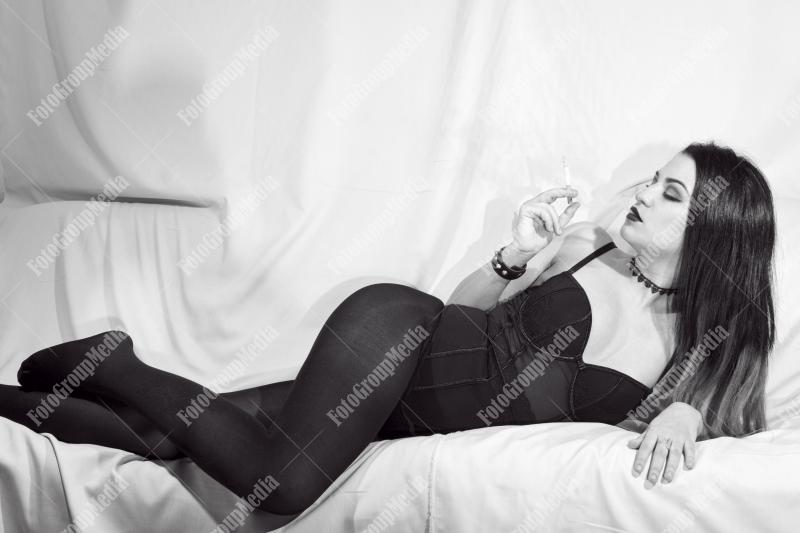 A modern femme fatale lounges on a plush sofa