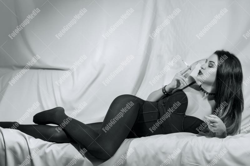 A modern femme fatale lounges on a plush sofa